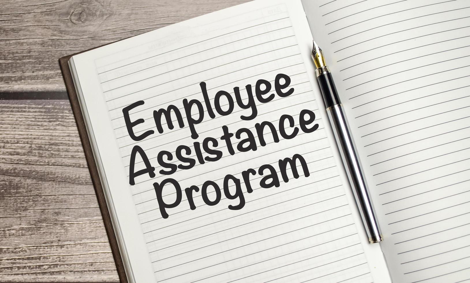 EAP Employee Assistance Program. concept words on notepad and calculator and wooden background photo