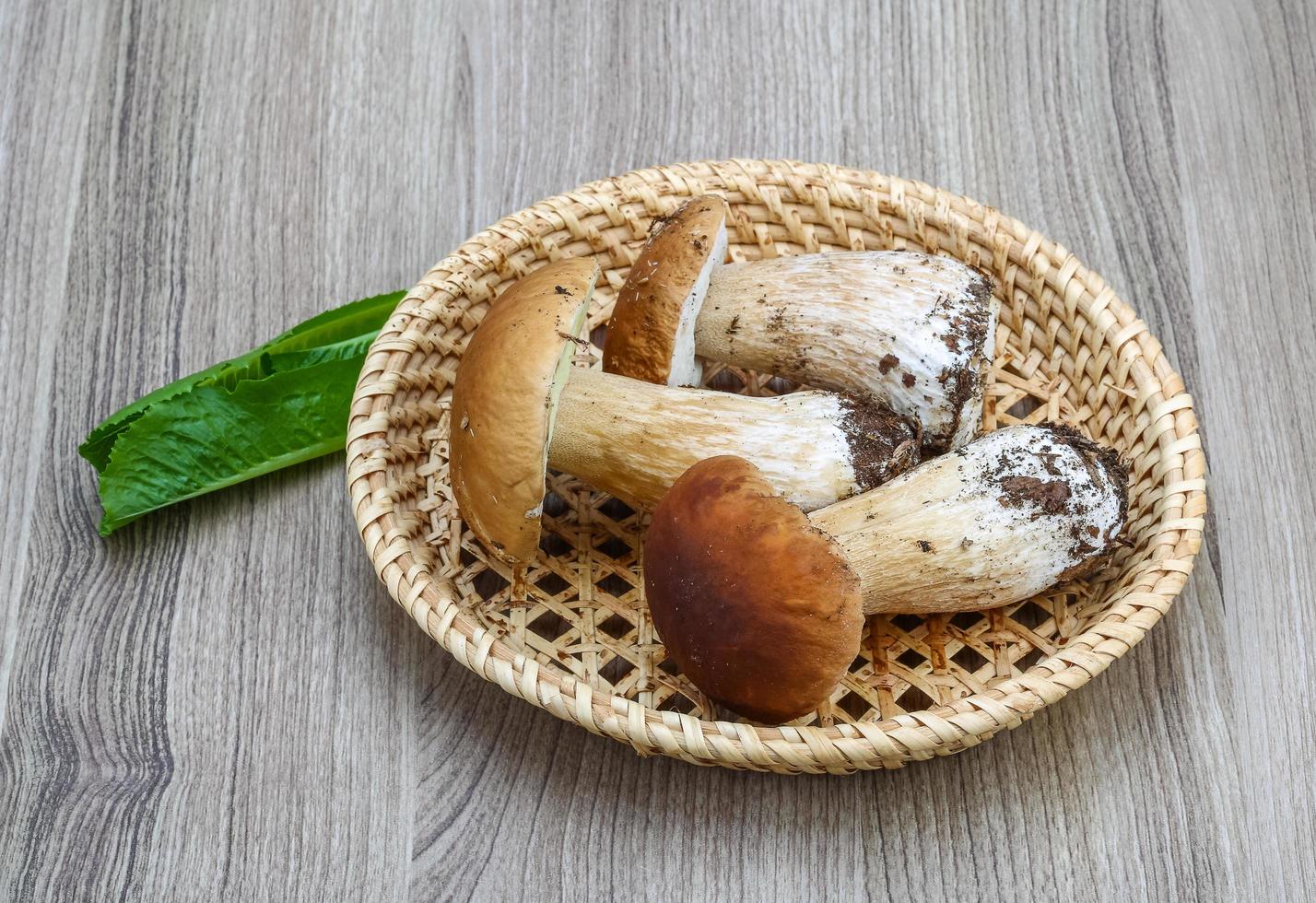 Wild Mushrooms in a basket on wooden background photo
