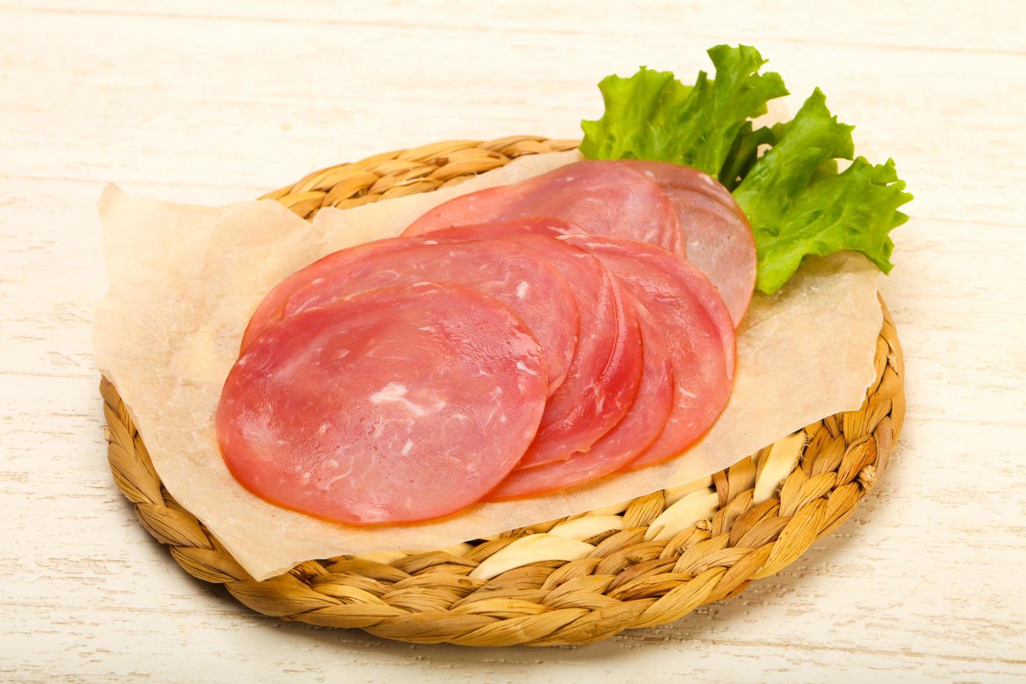 Sliced sausage on wooden board and wooden background photo