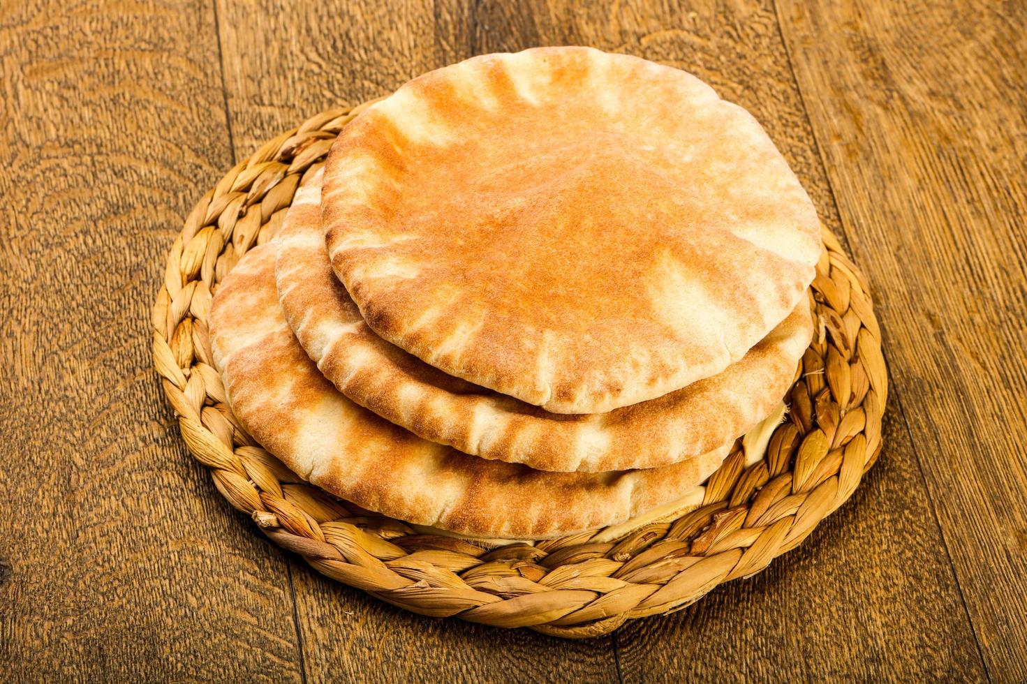 Pita bread on wooden board and wooden background photo