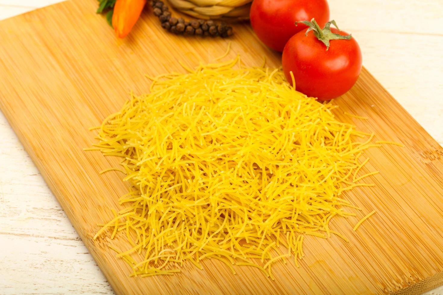 Raw noodle on wooden board and wooden background photo