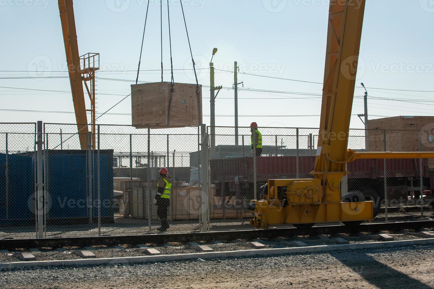 A truck crane on the railway tracks loads construction materials photo