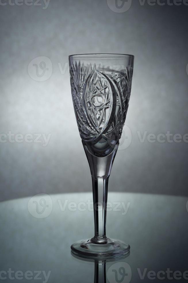 A vertical shot of an empty champagne glass on a grey background photo