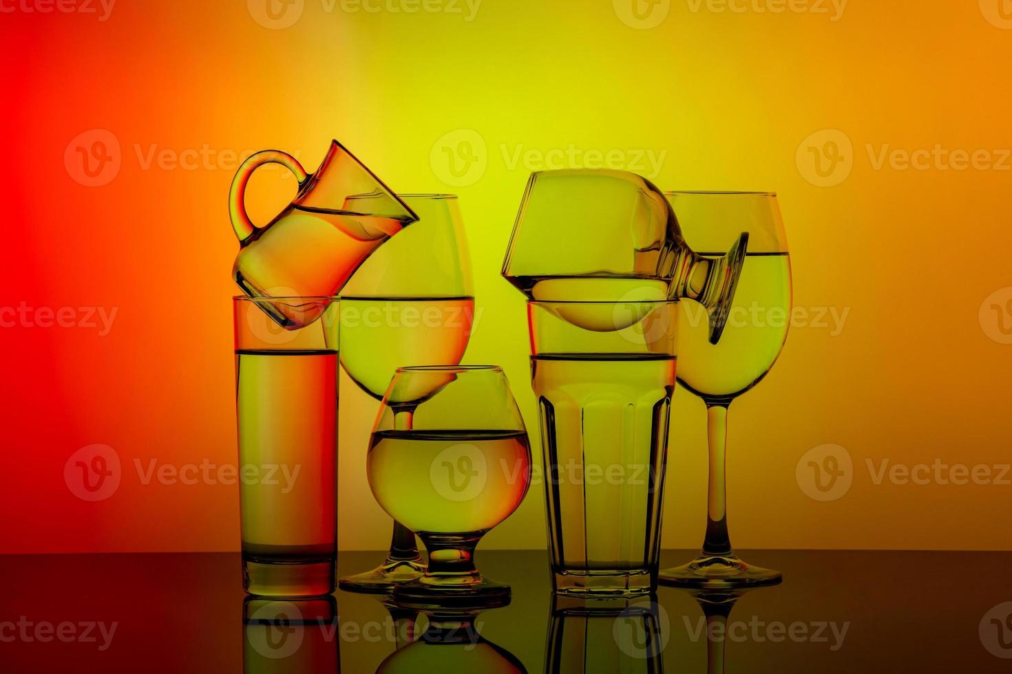 Some glasses for different drinks stacked on a colorful background photo