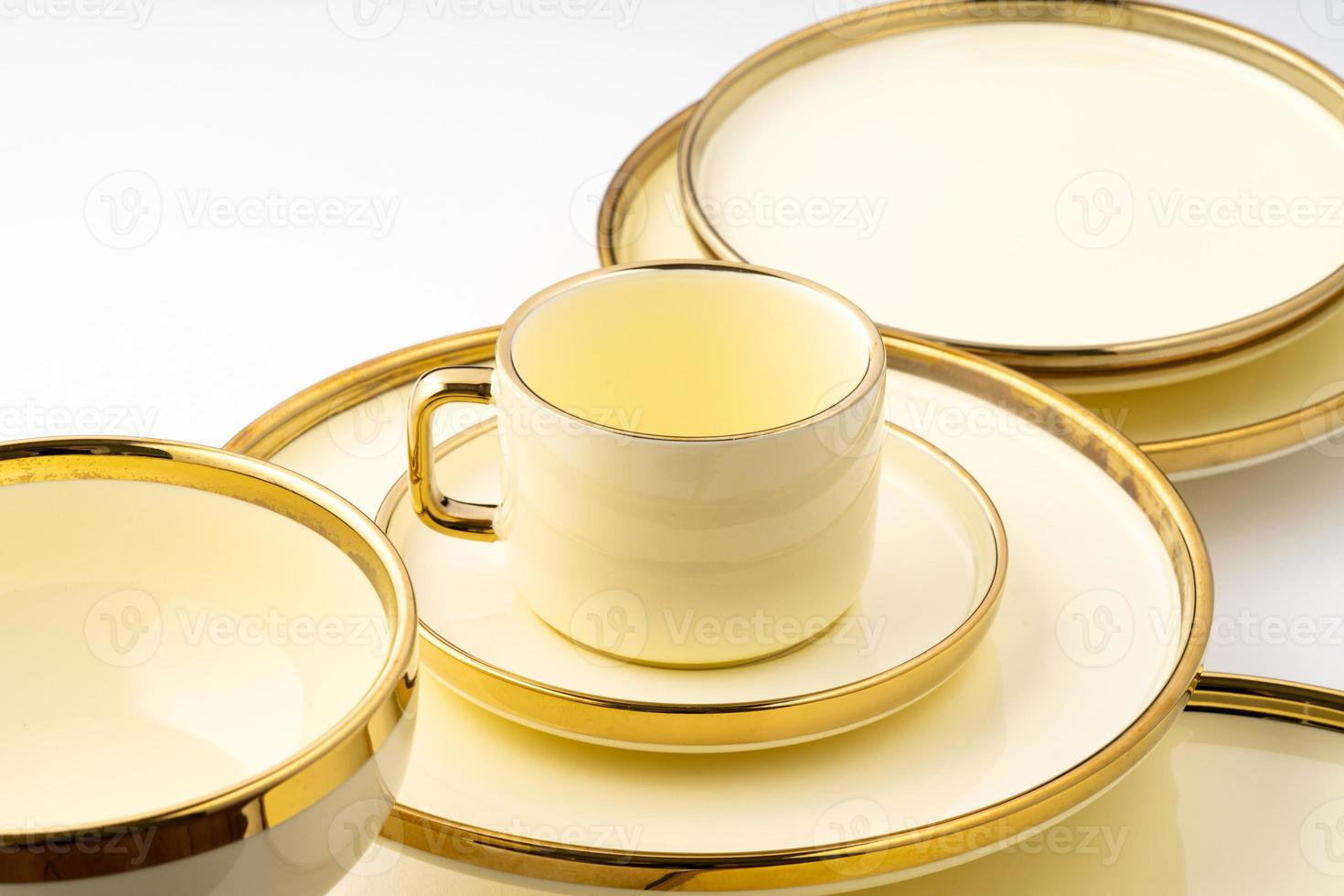 un primer plano de utensilios de cocina de cerámica de lujo dorados sobre un fondo blanco foto