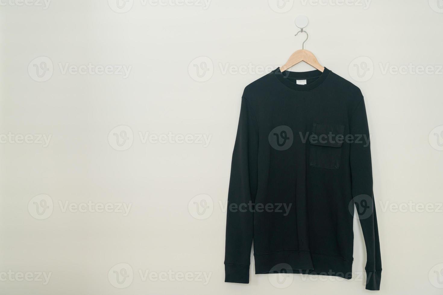 black sweater hanging on hanger photo