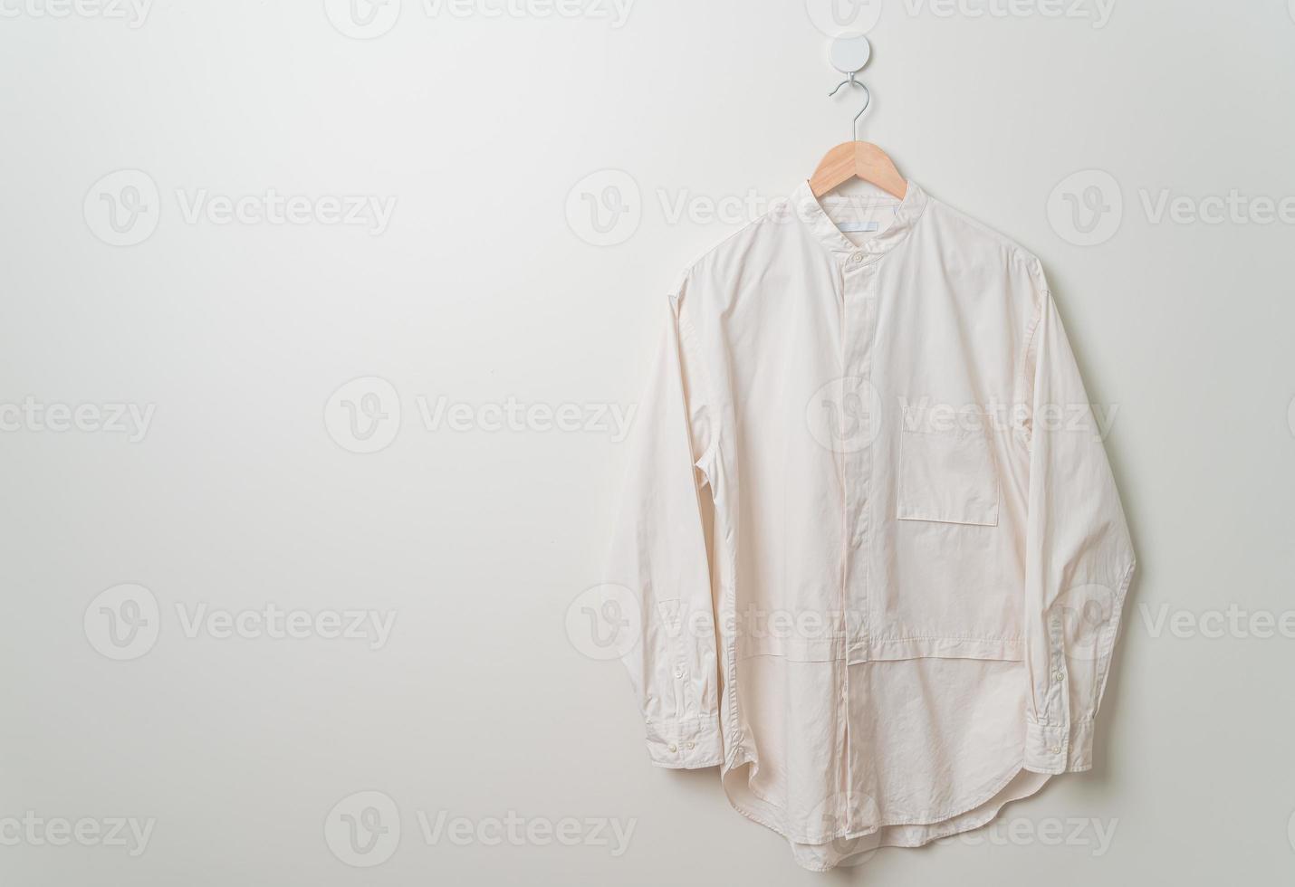 hanging shirt with wood hanger on wall photo