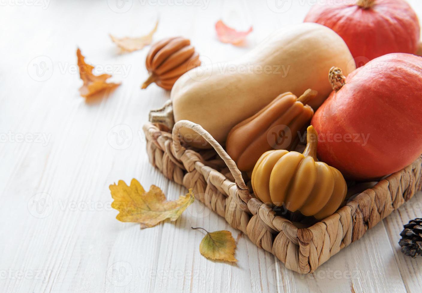 calabazas decorativas de otoño con hojas de otoño sobre fondo de madera. foto