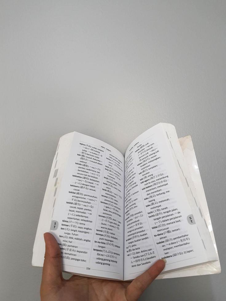 West Java, August 2022. A hand is holding a Japanese-Indonesian dictionary for students, students and the general public photo