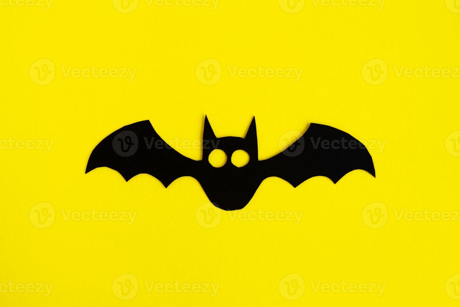 decoraciones navideñas para halloween. murciélago de papel negro sobre un fondo amarillo, vista superior. foto