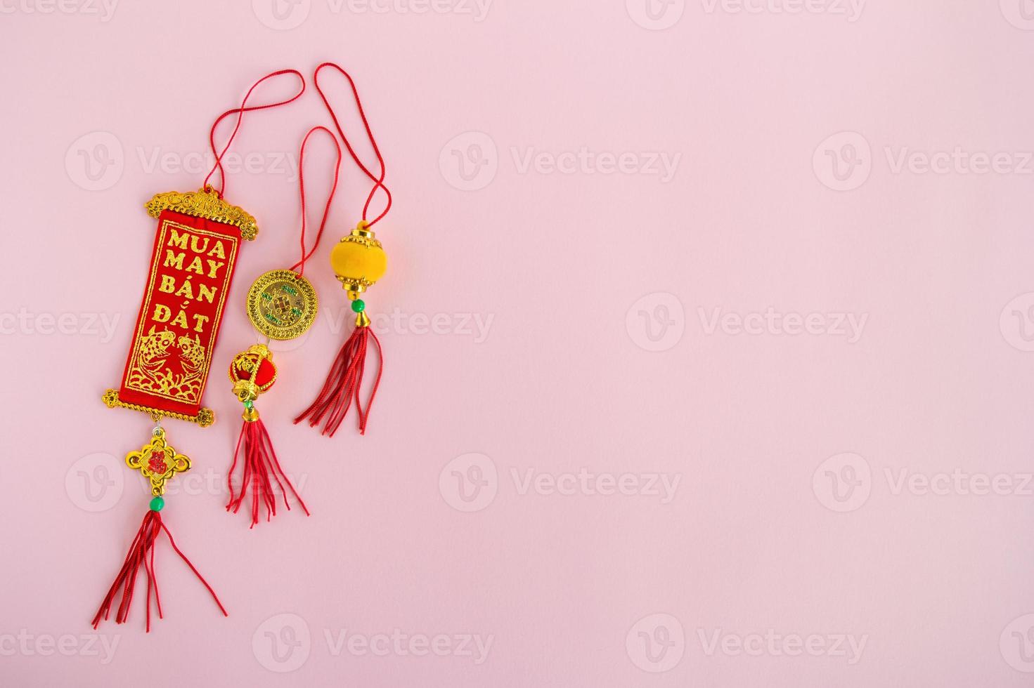 Traditional Vietnamese and Chinese New Year decorations red and golden colors on a pink background, top view. photo