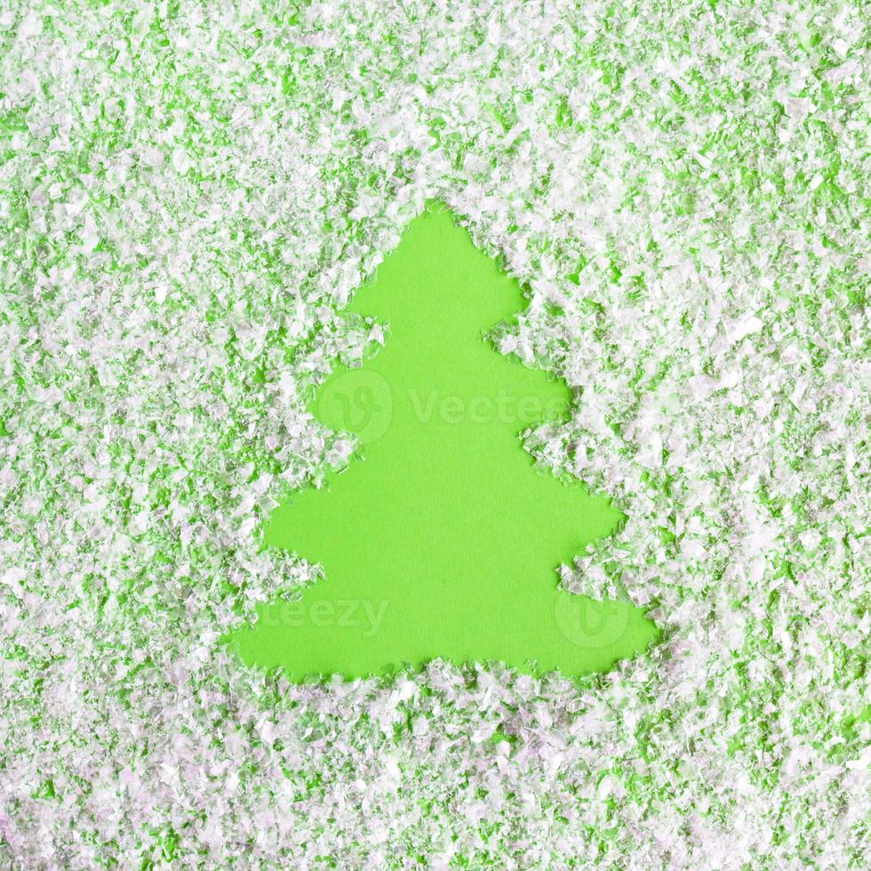 Winter composition with Christmas tree on a green background with artificial snow, flat lay. Greeting card for New Year with copy space. photo