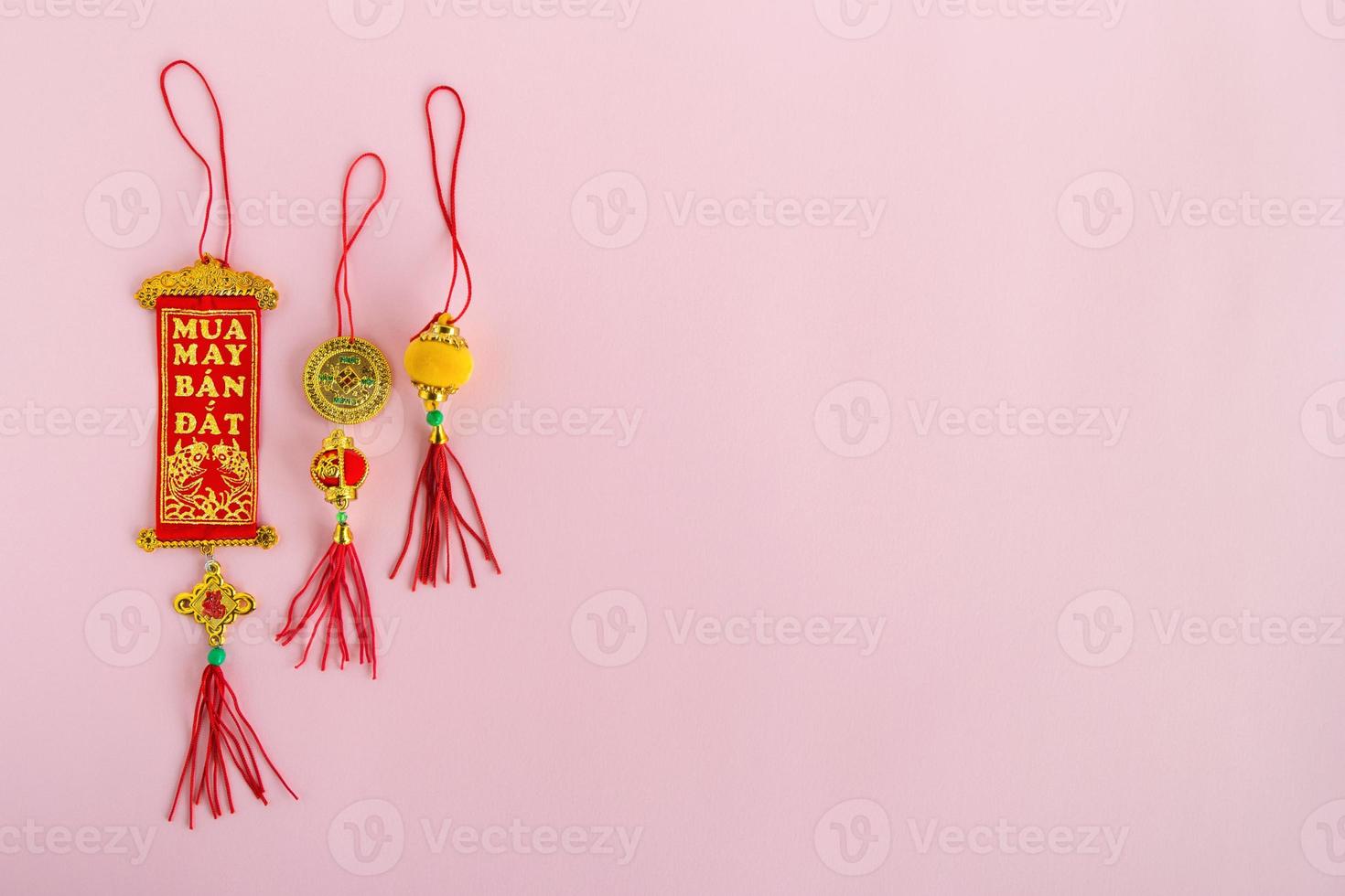 Traditional Vietnamese and Chinese New Year decorations red and golden colors on a pink background, top view. photo