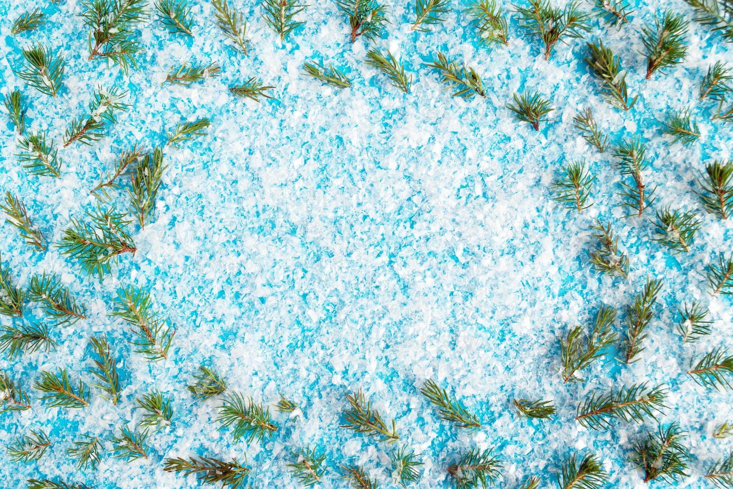 Frame from fir branches on a blue background with artificial snow, top view. Christmas and New Year concept with copy space. photo