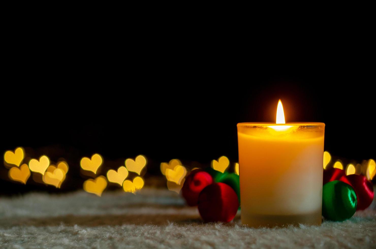 Candle lights and Christmas ornaments with golden love shape bokeh lights. Christmas and New year concept. photo