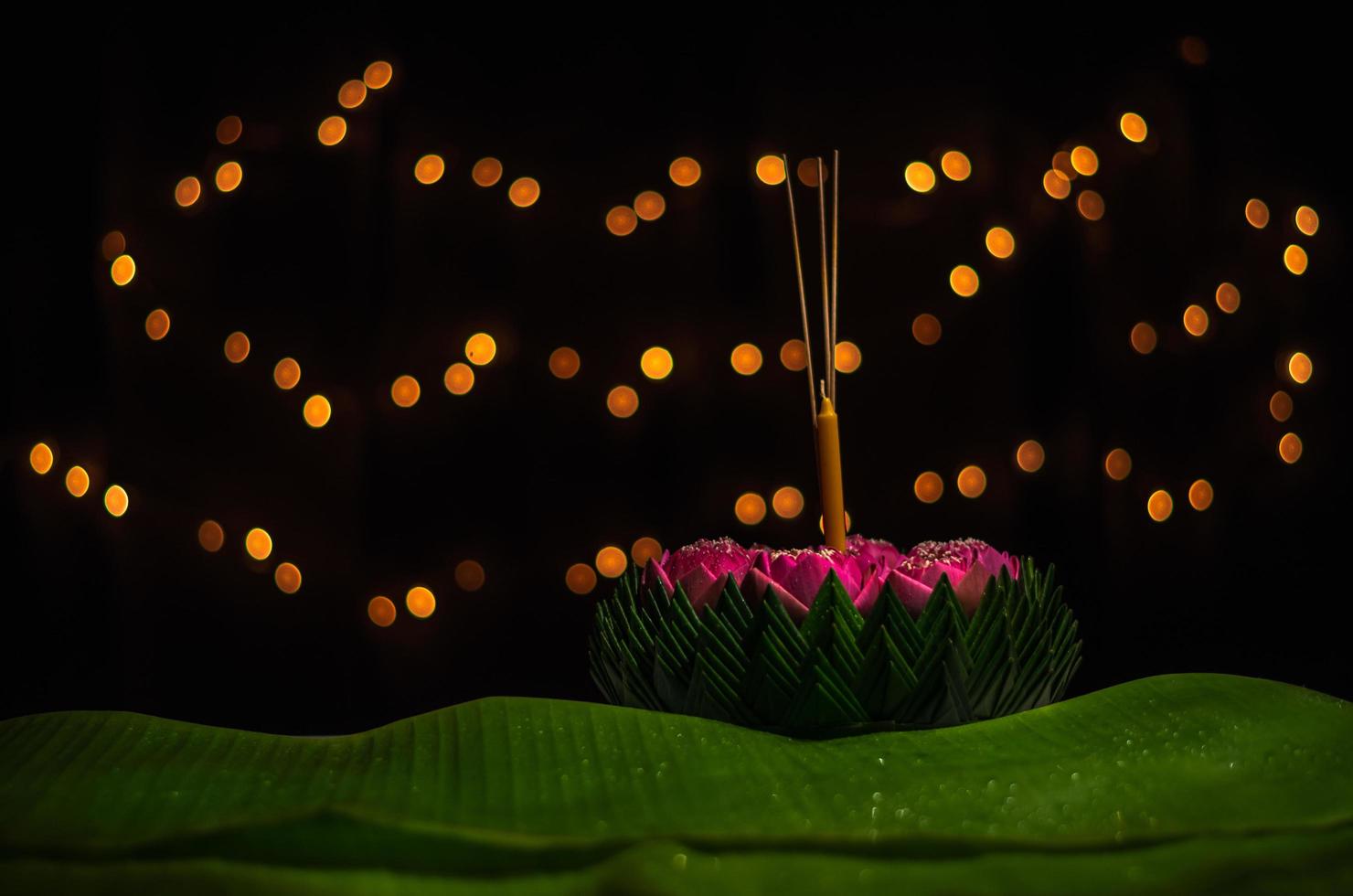 Banana leaf Krathong with 3 incense sticks and candle decorates with pink lotus flower for Thailand Full moon or Loy Krathong festival. photo