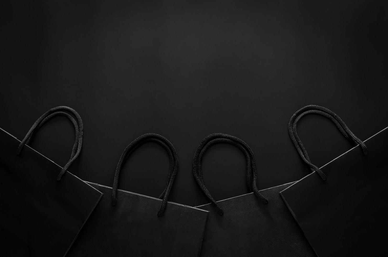 Black shopping paper bags on black background for Black Friday shopping