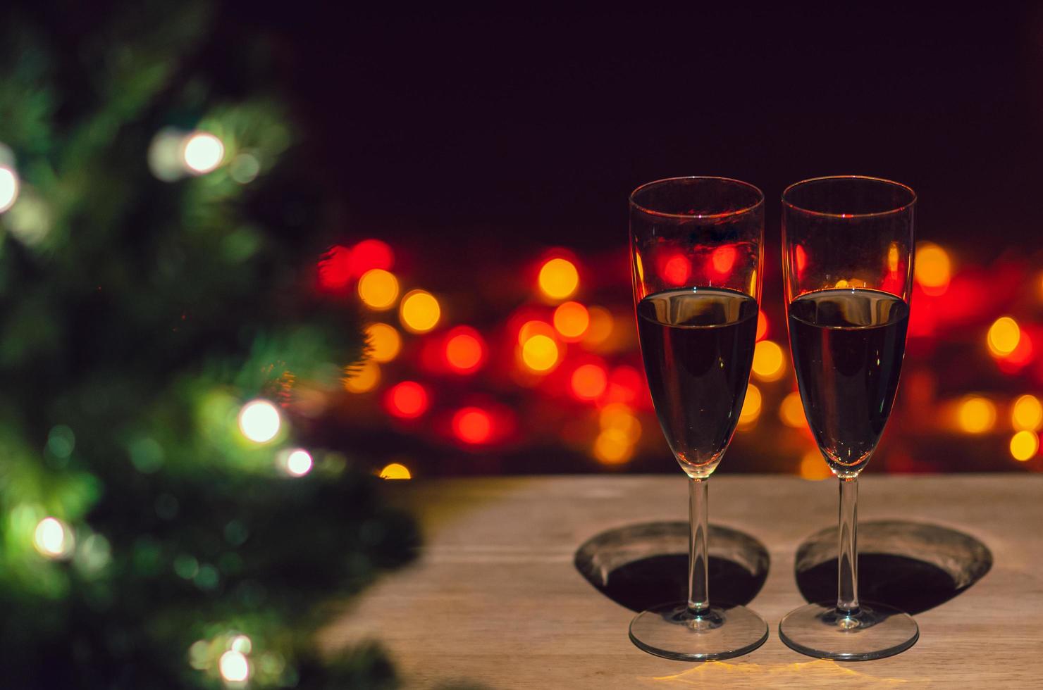 Two glasses of Rose wine on wooden table with Christmas tree and