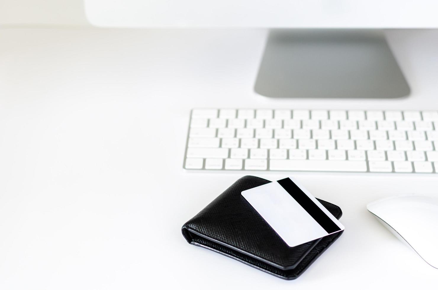 Selective focus on black wallet and credit card with wireless keyboard, mouse and computer screen for online shopping and Cyber Monday concept. photo