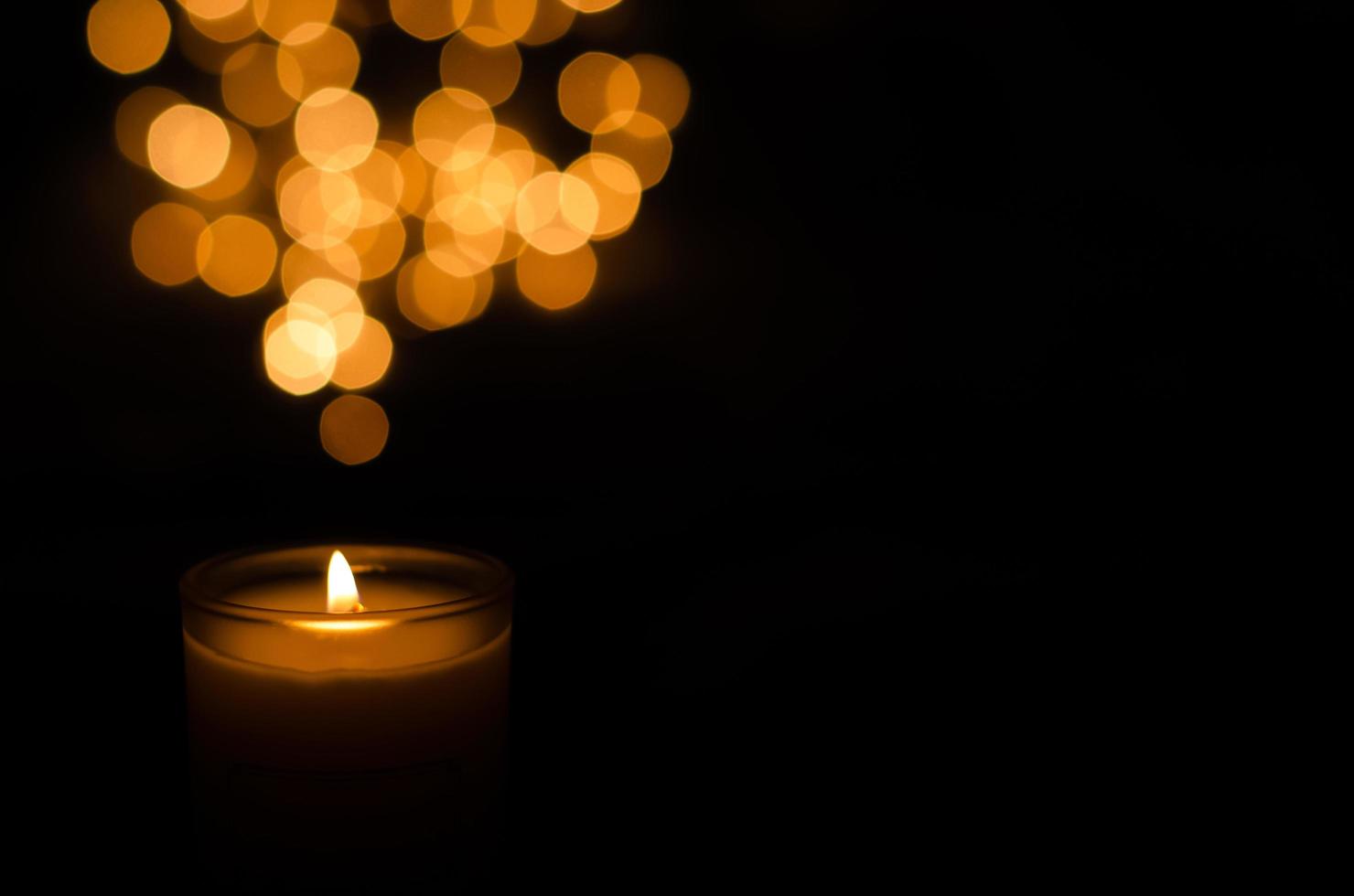 Aromatic candle with flame and round shape bokeh on dark background for Thanks giving and Christmas day. photo