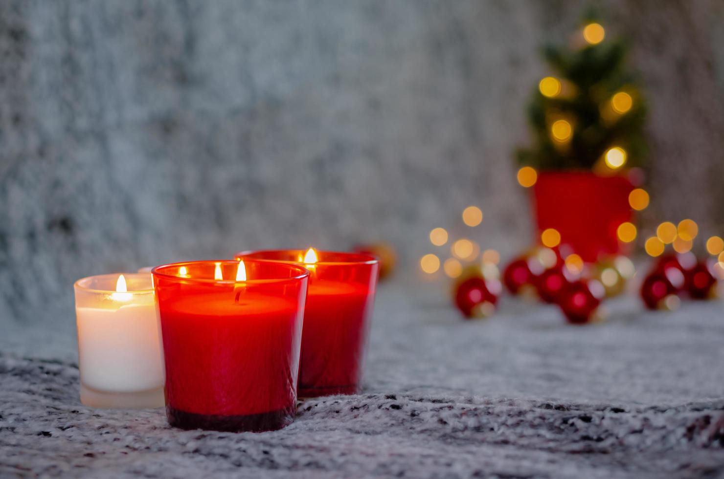 foco y borroso de velas encendidas con fondo de luz bokeh del árbol de navidad. foto