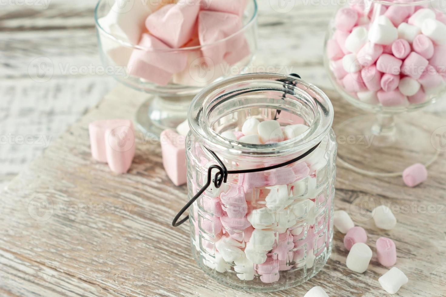 Assorted pink and white marshmallows in glass cups on wooden background. Heart shape marshmallow for hot chocolate or cacao photo