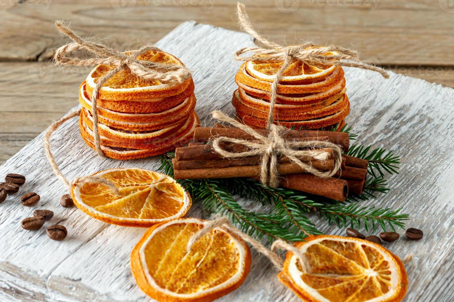 Christmas composition. Arrangement of dry Oranges, cinnamon sticks, fur tree branches and walnuts on wooden background. Rustic, Holiday spices ingredients photo