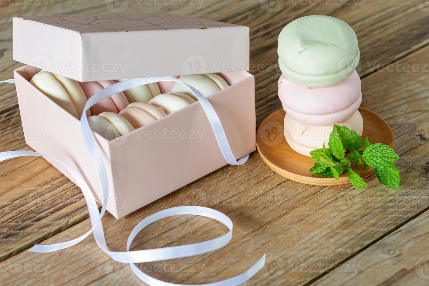 Gift box with homemade pastel multi color marshmallows. Apple zephyr in round shape. delicious fruit dessert on wooden table photo