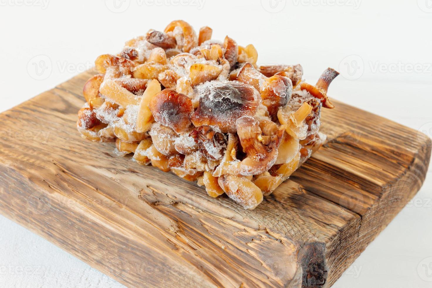 Semi-finished products. Frozen food. Agaric of honey mushrooms on cutting board. photo