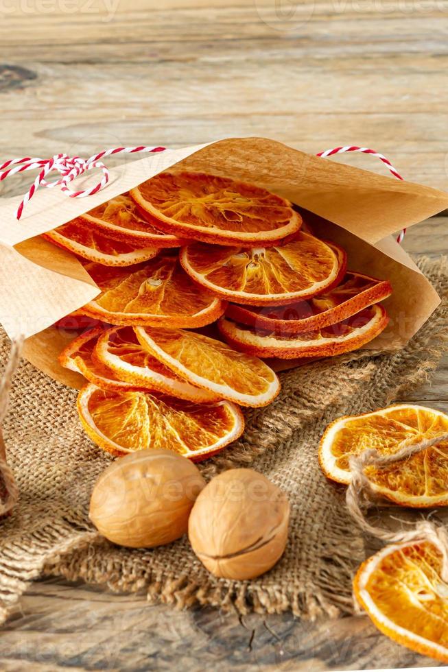 Christmas composition. Arrangement of dry Oranges, cinnamon sticks and walnuts on wooden background. Rustic, Holiday spices ingredients photo