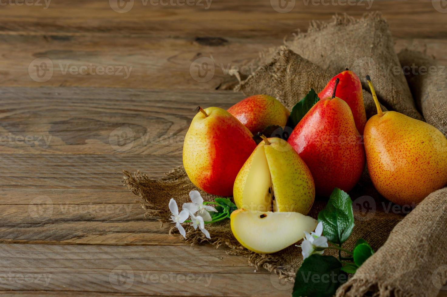 Ripe pears fruit. Harvested organic pear on burlap on wooden table. Autumn harvest. photo