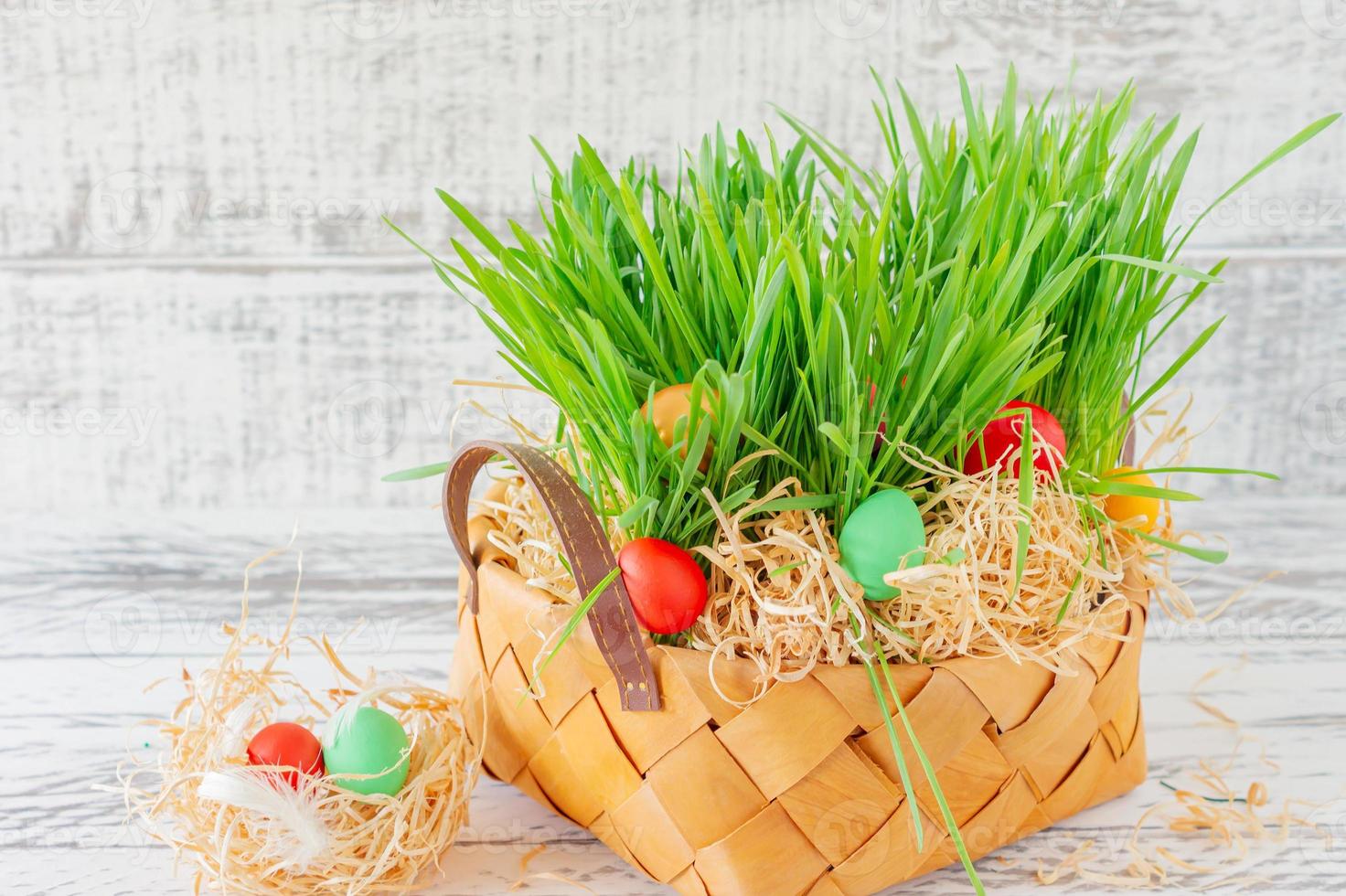 Easter basket with green grass filled with brightly colored Easter eggs. Happy Easter. photo