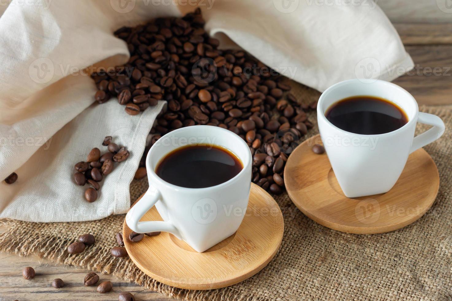 Two cups of freshly brewed espresso on wooden table. coffee beans on light wooden table, rustic style, homemade. photo