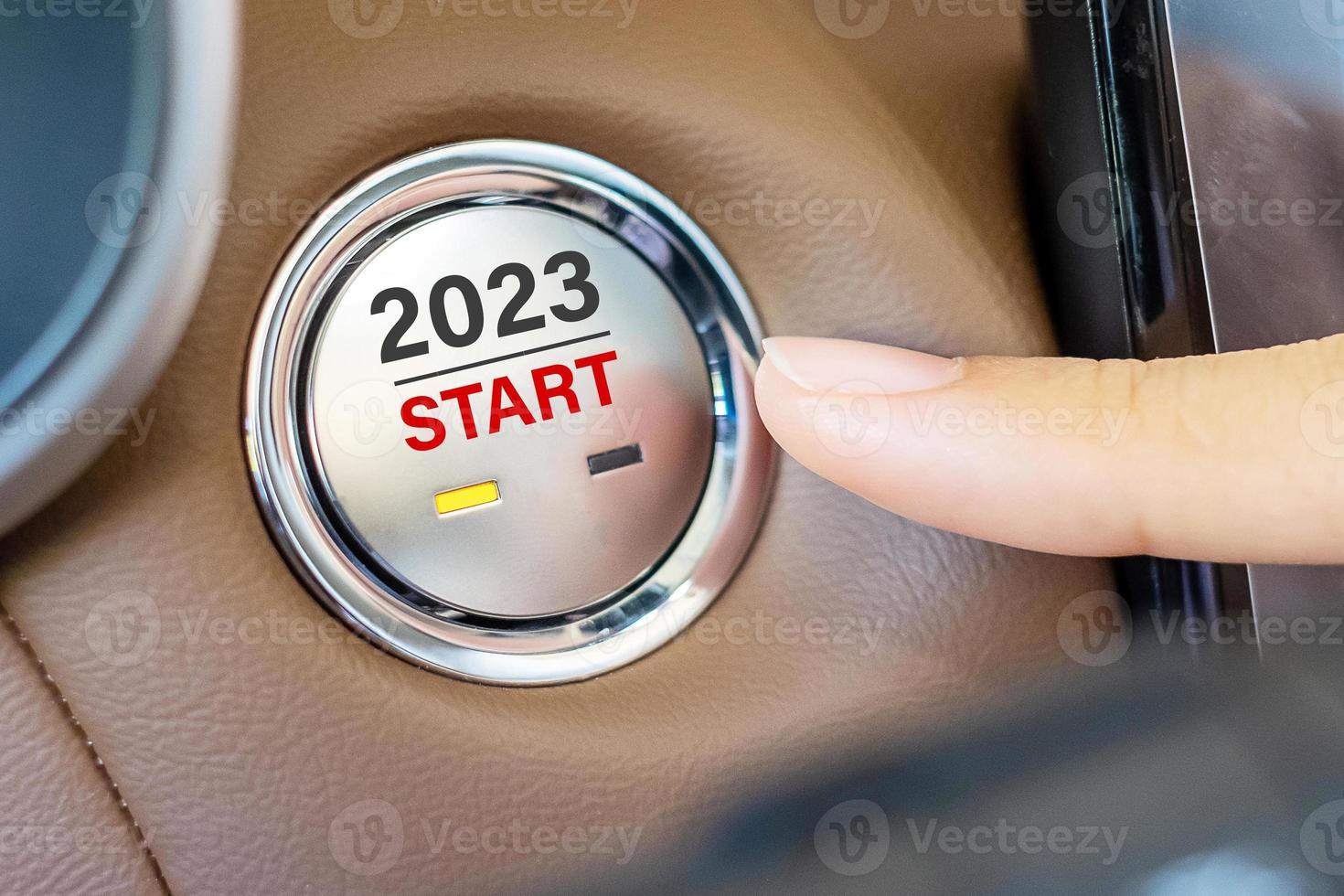 Finger press a car ignition button with 2023 START text inside  automobile. New Year New You, forecast, resolution, motivation, change, goal, vision, innovation and planning concept photo