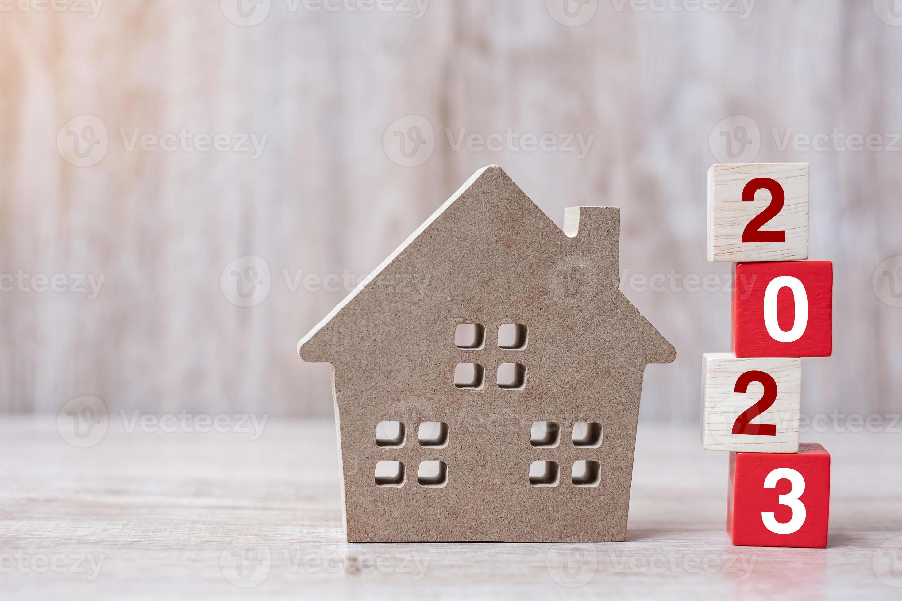 2023 Happy New Year with house model on table wooden background. Banking,  real estate, investment, financial, savings and New Year Resolution  concepts 12855871 Stock Photo at Vecteezy