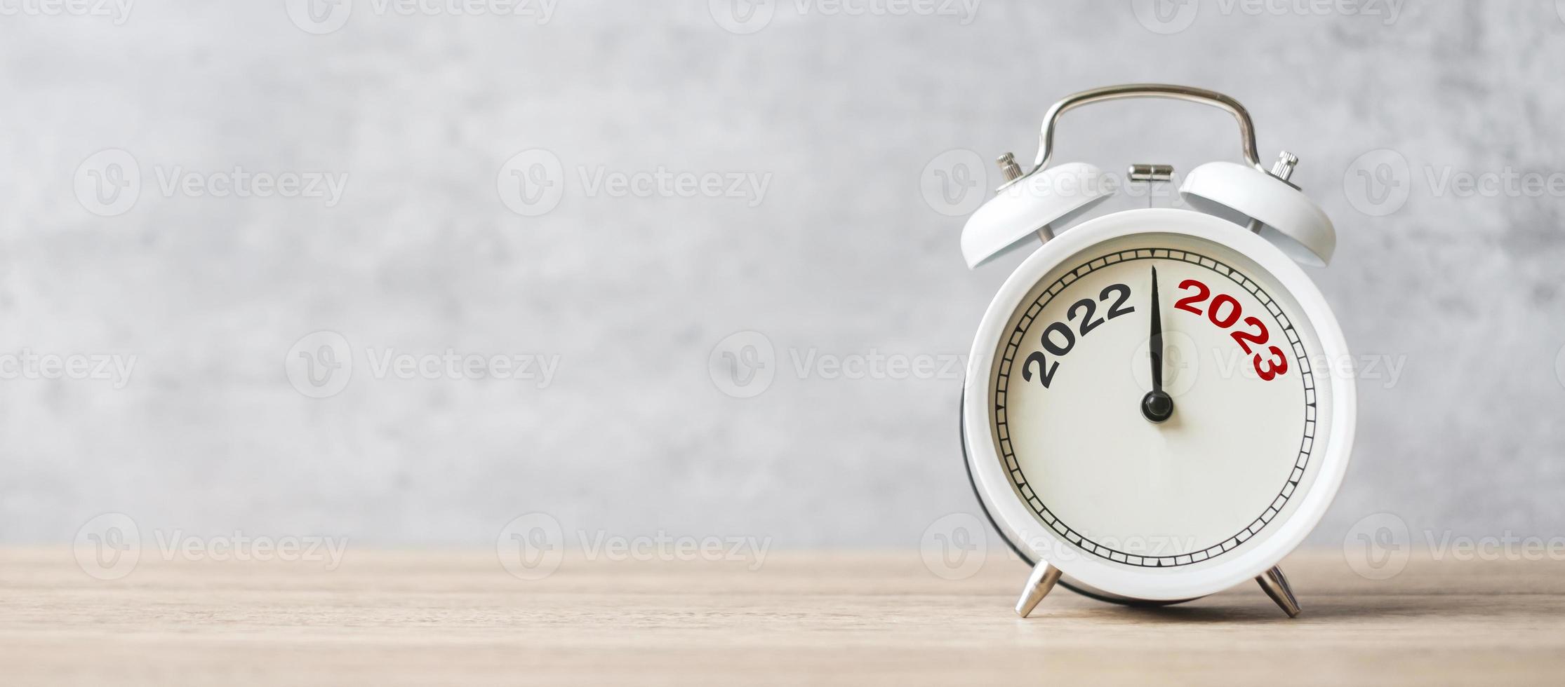 Happy New Year with vintage alarm clock and 2022 change to 2023 number. Merry Christmas, New Start, Resolution, countdown, Goals, Plan, Action and Mission Concept photo