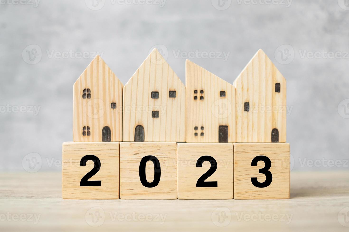 2023 Happy New Year with house model on table. Banking, real estate, investment, financial, savings and New Year Resolution concepts photo