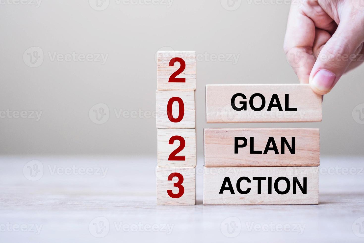 hand holding wooden block with text 2023 GOAL, PLAN and ACTION on table background. Resolution, strategy, solution, goal, business and New Year holiday concepts photo