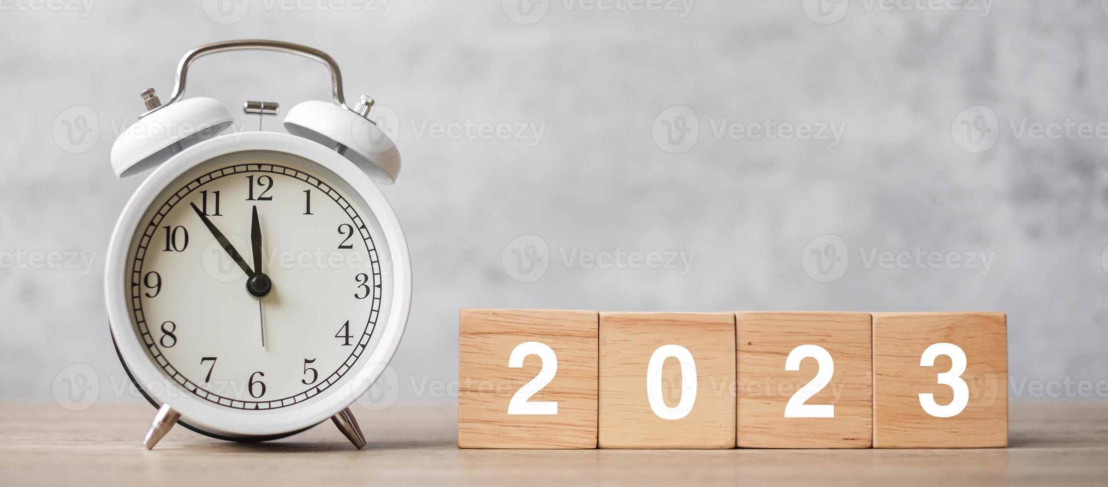 Happy New Year with vintage alarm clock and 2023 block. Christmas, New Start, Resolution, countdown, Goals, Plan, Action and Motivation Concept photo