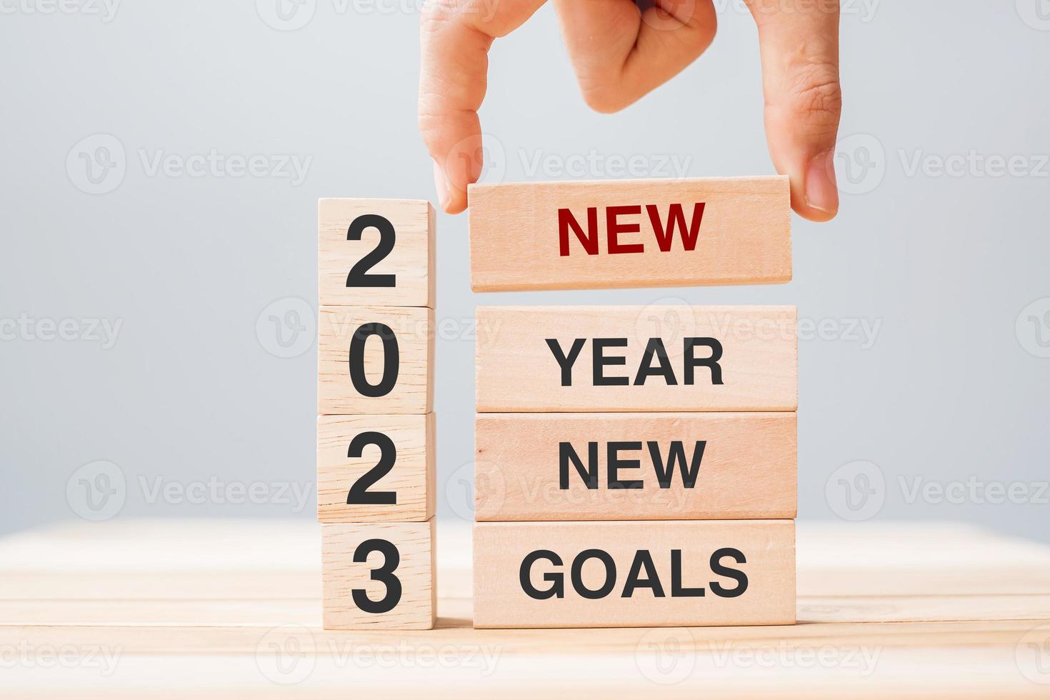 hand holding wooden block with text 2023 NEW YEAR NEW GOALS on table background. Resolution, strategy, solution, business and holiday concepts photo