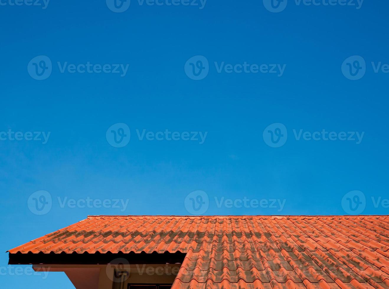 las tejas del techo del edificio tienen un fondo de cielos azules de cielo brillante. foto