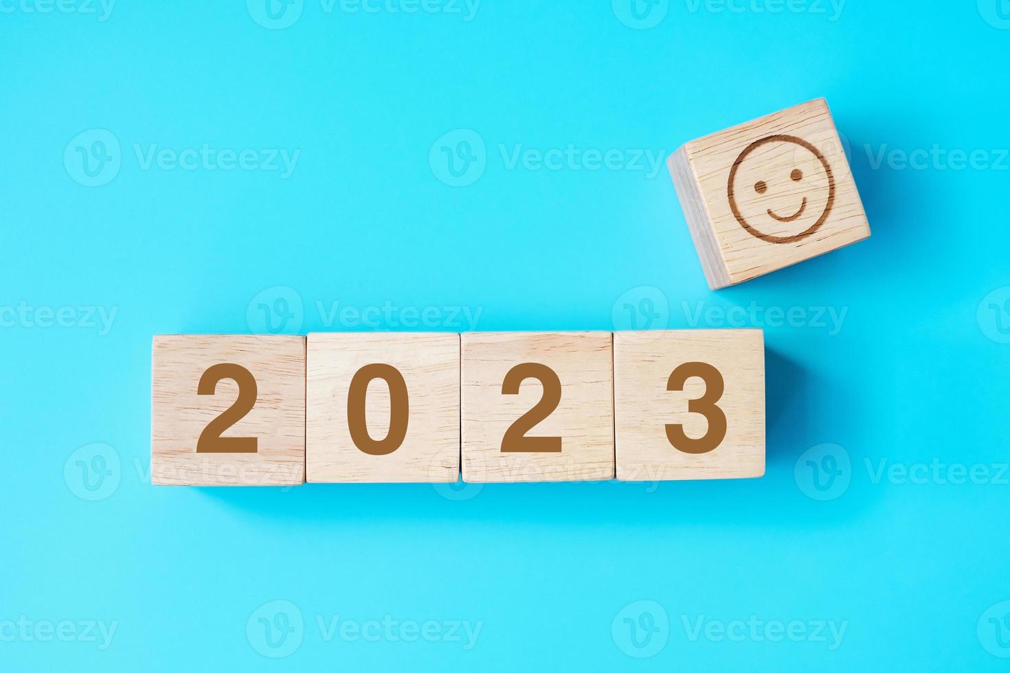 bloque de cara sonriente con texto 2023 sobre fondo azul. conceptos de satisfacción, retroalimentación, revisión y año nuevo foto