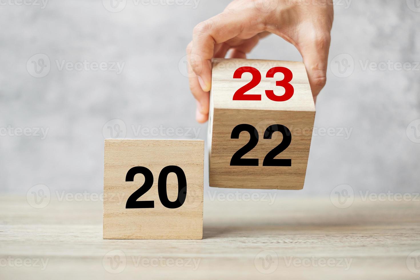 hand flipping block 2022 to 2023 text on table. Resolution, strategy, plan, goal, motivation, reboot, business and New Year holiday concepts photo