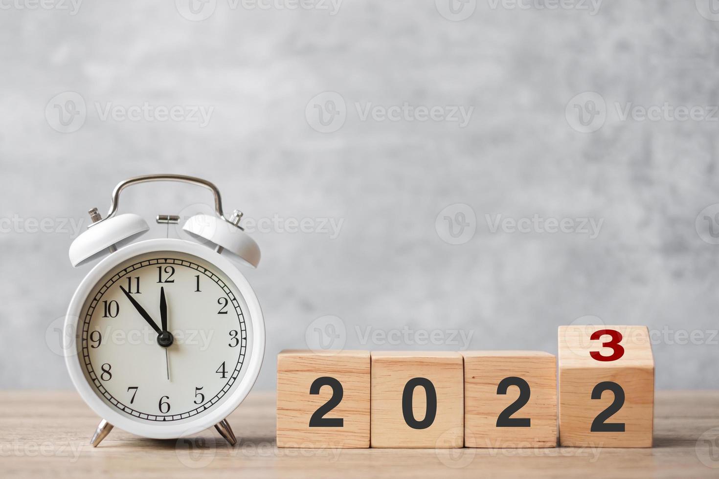Happy New Year with vintage alarm clock and flipping 2022 change to 2023 block. Christmas, New Start, Resolution, countdown, Goals, Plan, Action and Motivation Concept photo