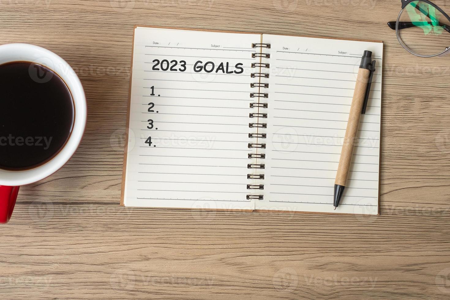 2023 GOAL with notebook, black coffee cup and pen on wood table, Top view and copy space. Happy New Year, Resolution, To do list, Strategy and Plan concept photo