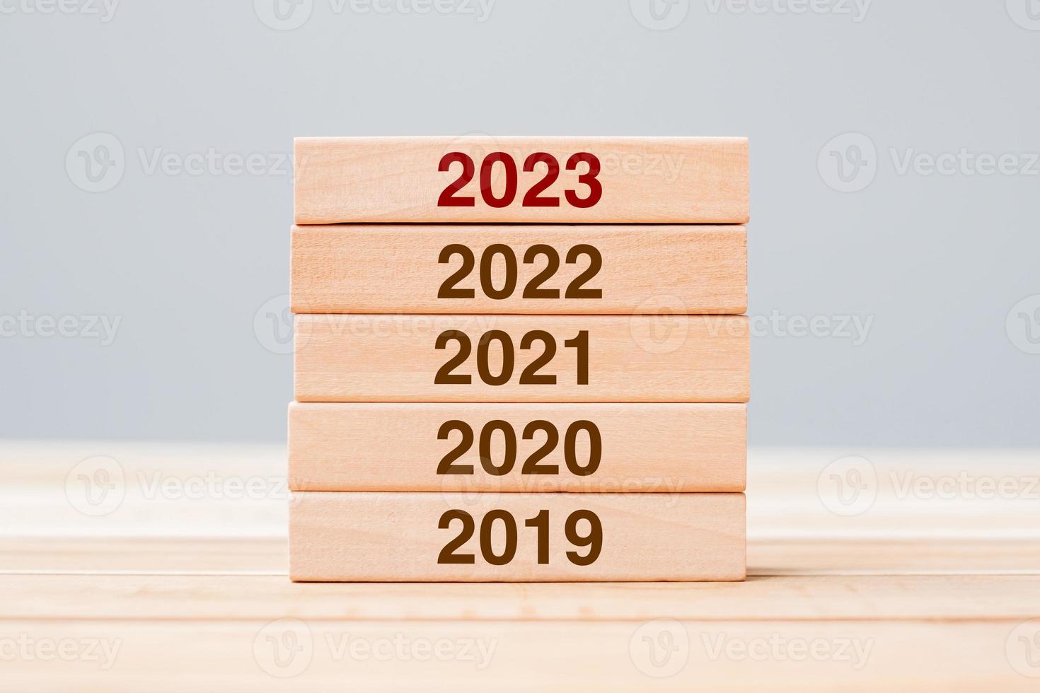 2023 bloque sobre 2022 y 2021 edificio de madera sobre fondo de mesa. planificación empresarial, gestión de riesgos, resolución, estrategia, solución, objetivo, nuevo año nuevo y felices conceptos de vacaciones foto