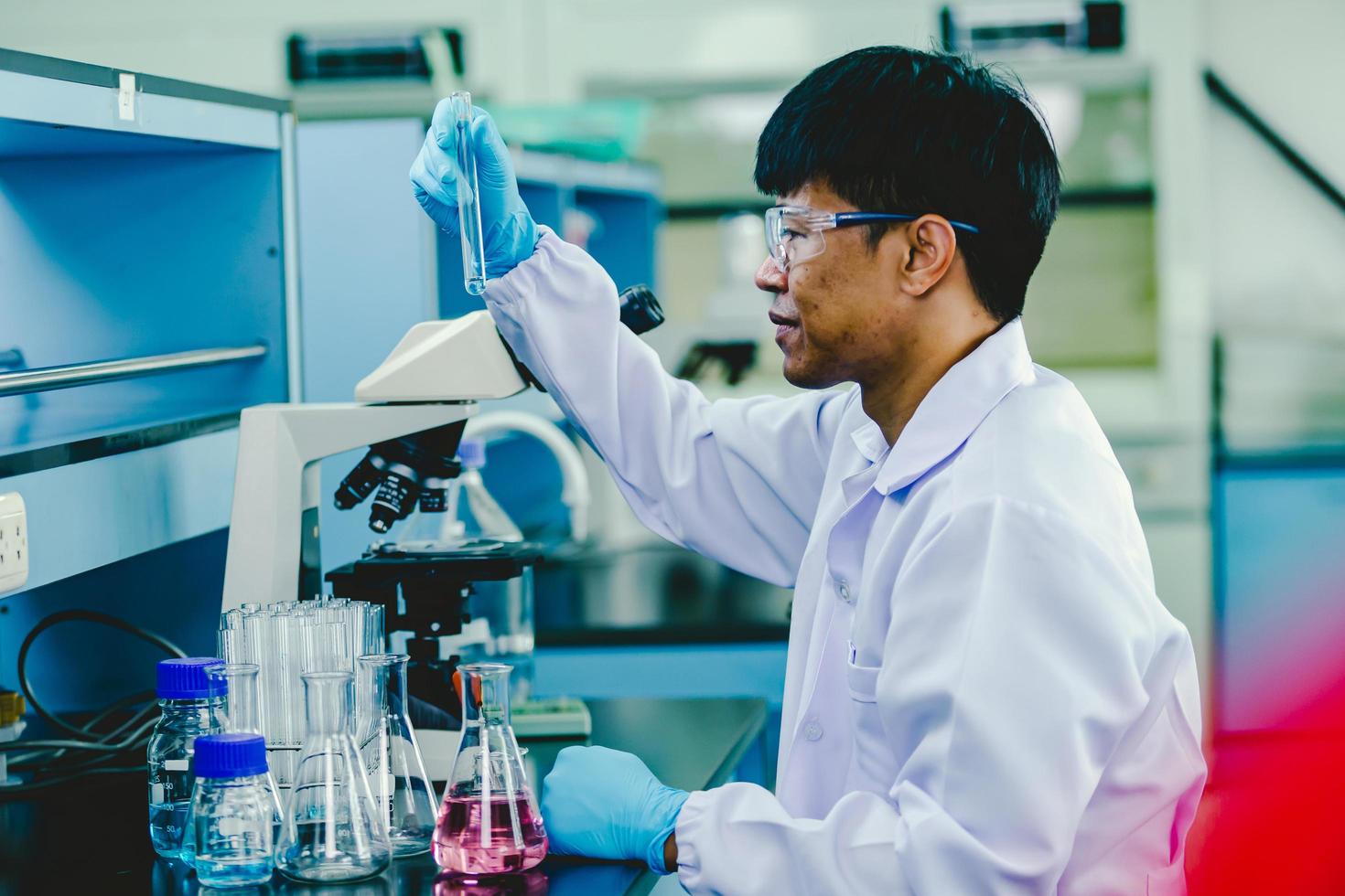 Asian male chemist wearing glasses and white lab working in laboratory 12857333 Stock Photo at