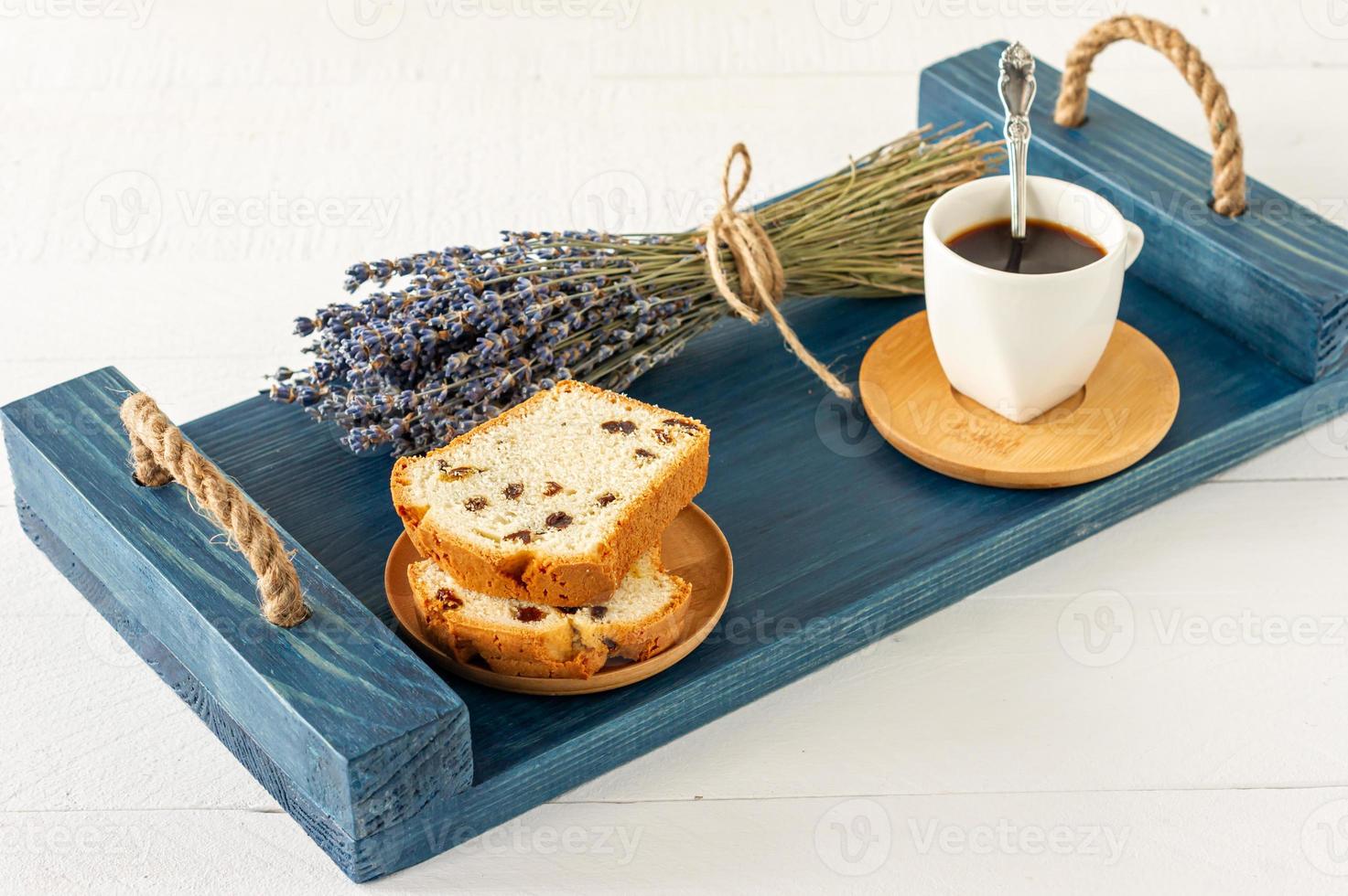 Slices of pound cake with raisins and a cup of coffee served on a tray. Morning tasty breakfast photo