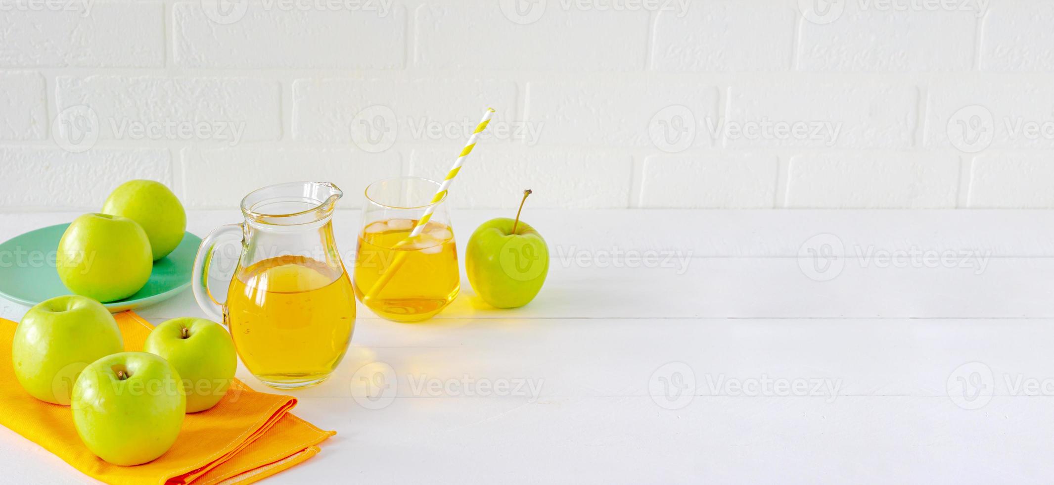 Fresh homemade apple juice and green apples on white table. Healthy morning beverage. photo