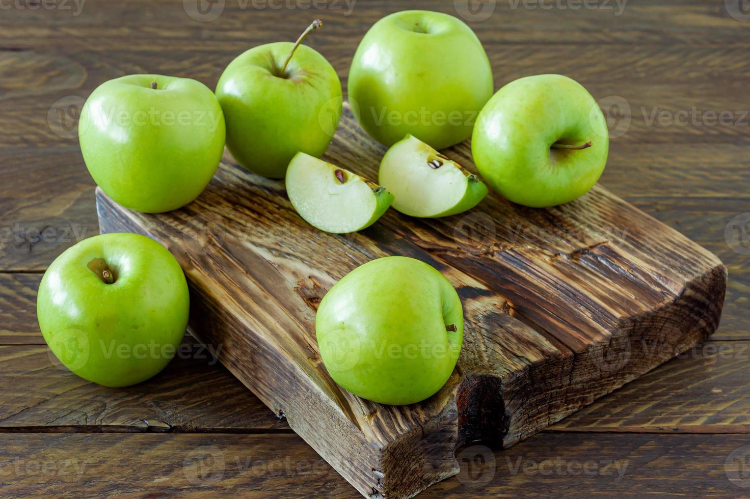 manzanas maduras verdes en el escritorio de madera. estilo rústico agricultura ecológica. comida sostenible foto